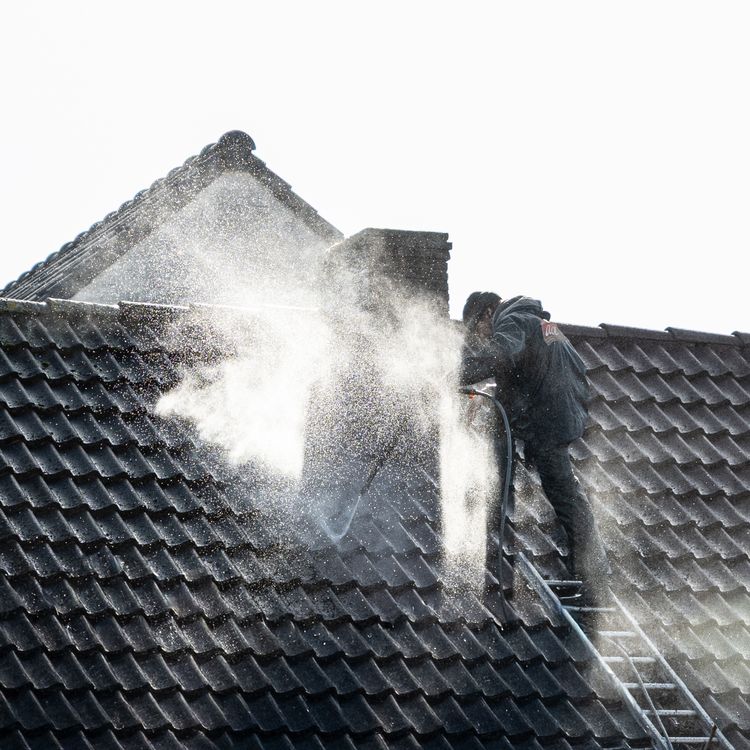 Roofing professional applying a roof treatment