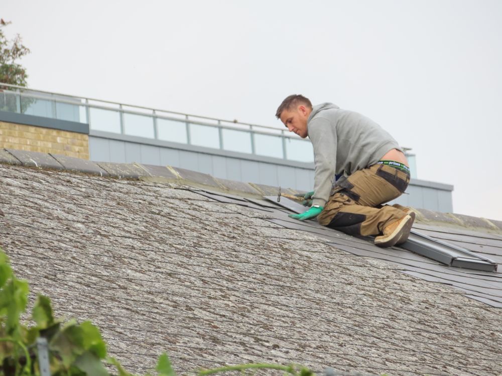 Roofer checking and installing asphalt shingles