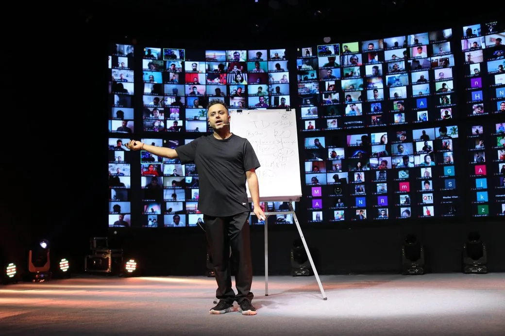 Saurabh Bhatnagar teaching on stage in front of a wall of live attendees
