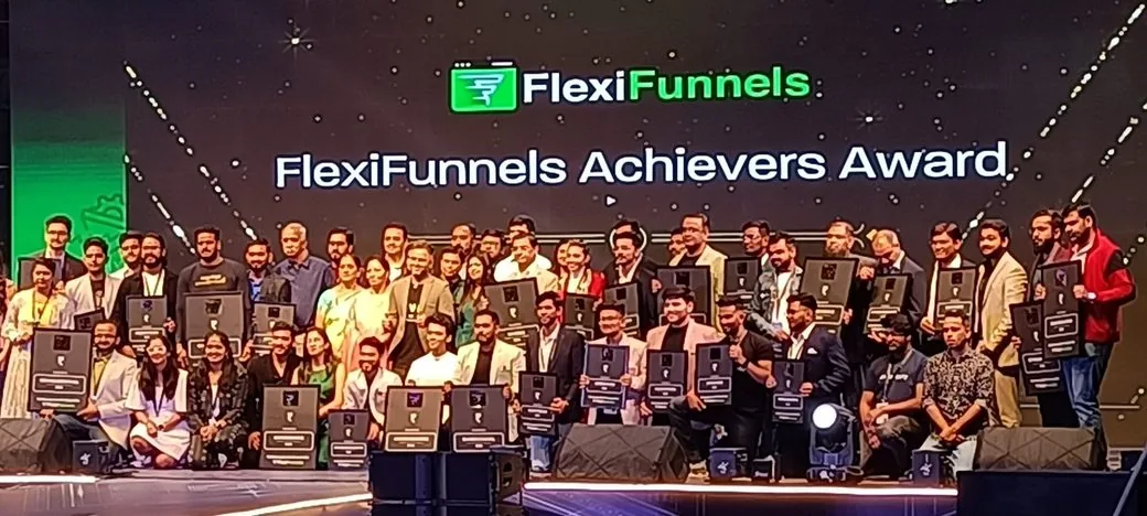 Customers on stage holding their FlexiFunnels Achievers Awards